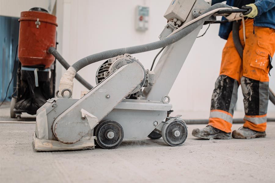 Floor preparation machine and dust extractor at work on a job site